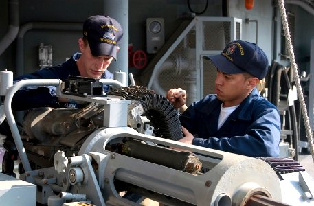 US Navy 070213-N-2638R-002 Gunner's Mate 3rd Class Shawn Branum and Gunner's Mate Seaman William Rivera clean a 25mm chain gun system aboard the Ticonderoga-class guided-missile cruiser USS Cowpens (CG 63)