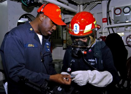 US Navy 070210-N-4649C-096 Chief Damage Controlman Enrique Jograj reviews the contents of a gas free kit to Engineman 2nd Class Jason Garcia during a main space fire drill aboard Arleigh Burke-class guided missile destroyer USS