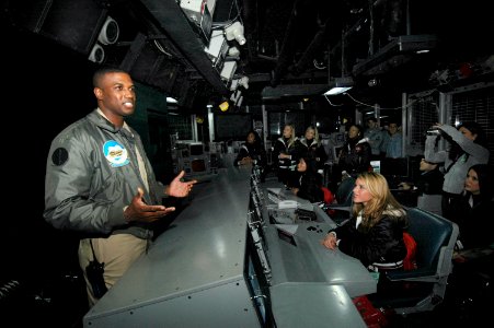 US Navy 070209-N-7883G-011 Lt. Arnold Roper, from Philadelphia, briefs the Tampa Bay Buccaneers Cheerleaders on the daily routine inside USS Kitty Hawk (CV 63) Combat Direction Center (CDC)