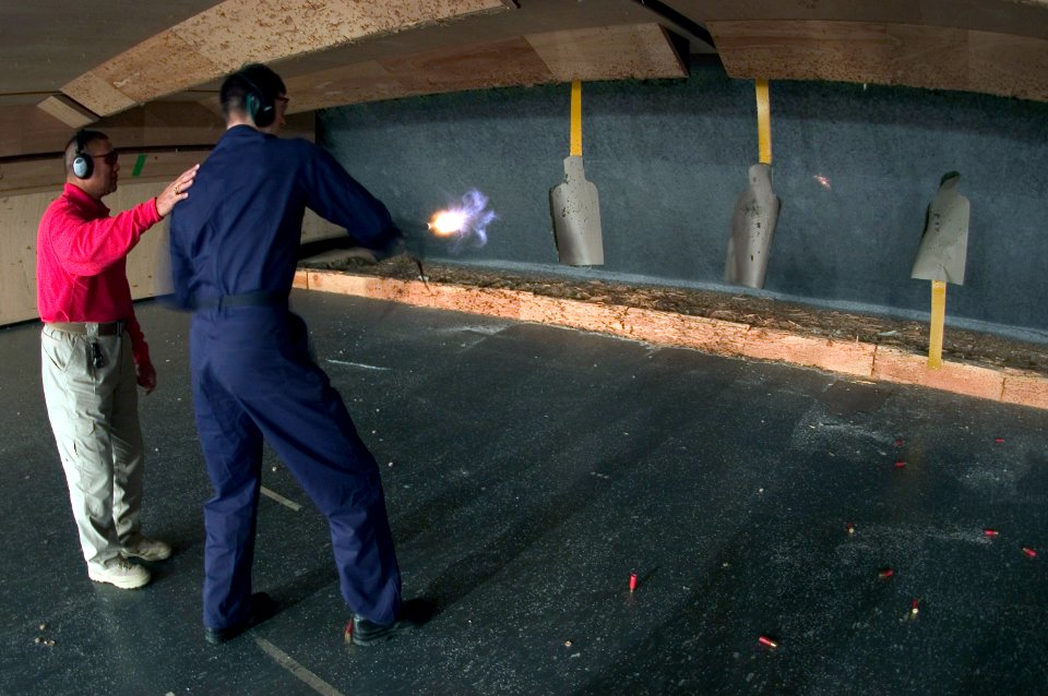 US Navy 070215-N-5253W-003 Instructor Fagaloa Kaleuati, from Homeland Security Solutions, coaches Information Systems Technician Seaman Benjamin Huyghebaert on the use of the 12-guage shotgun during a live-fire training course