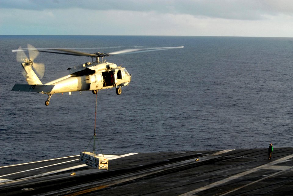 US Navy 070217-N-2959L-157 A landing signalman enlisted directs an MH-60S Seahawk assigned to the Island Knights of Helicopter Sea Combat Support Squadron Two Five (HSC-25) over the flight deck of USS Ronald Reagan (CVN 76) dur