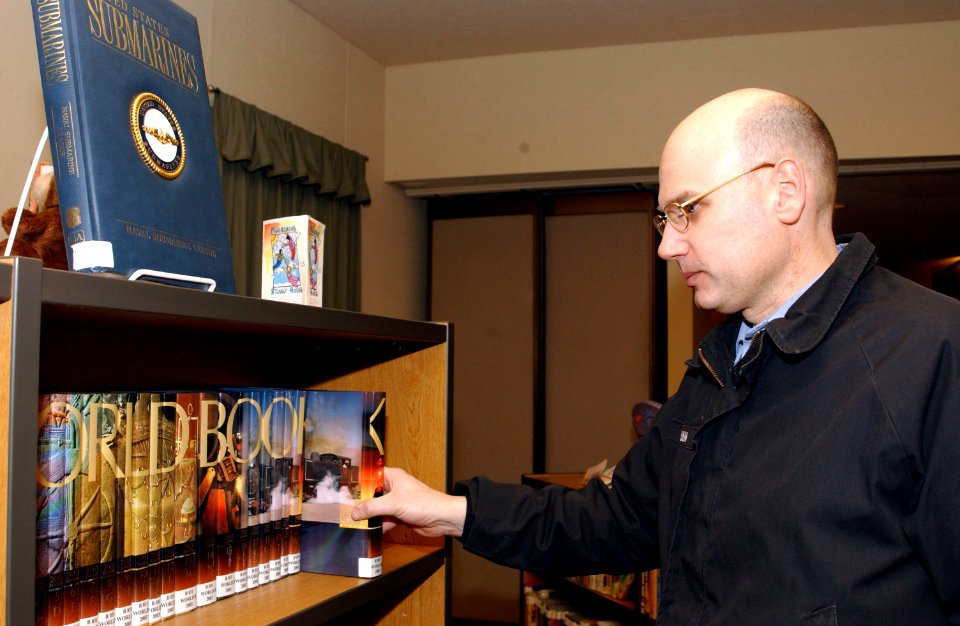 US Navy 070223-N-2143T-002 Storekeeper 2nd Class Mark Mckibbin assigned to fleet ballistic missile submarine USS Kentucky (SSBN 737) browses through books during his leisure time at the resource center
