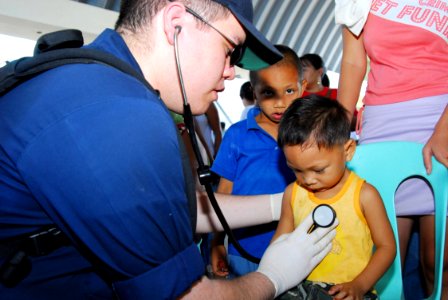 US Navy 070224-N-4124C-030 Hospitalman Frank N. Wilson, assigned to amphibious transport dock USS Juneau (LPD 10), performs a check up on a young Filipino boy during a medical civic action project (MEDCAP)