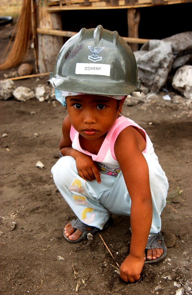 US Navy 070216-N-4198C-007 A four-year-old Filipino girl from the village of Changco, looks on as Seabees assigned to Naval Mobile Construction Battalion (NMCB) 3 work on the construction of a new school house