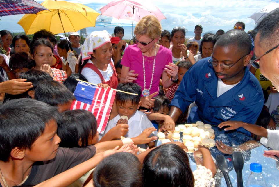 US Navy 070218-N-9860Y-667 The Honorable Kristie A. Kenney, U.S. Ambassador to the Philippines, greets students of Changco Elementary School while Intelligence Specialist 1st Class Darnell Harris hands out cookies during a dedi