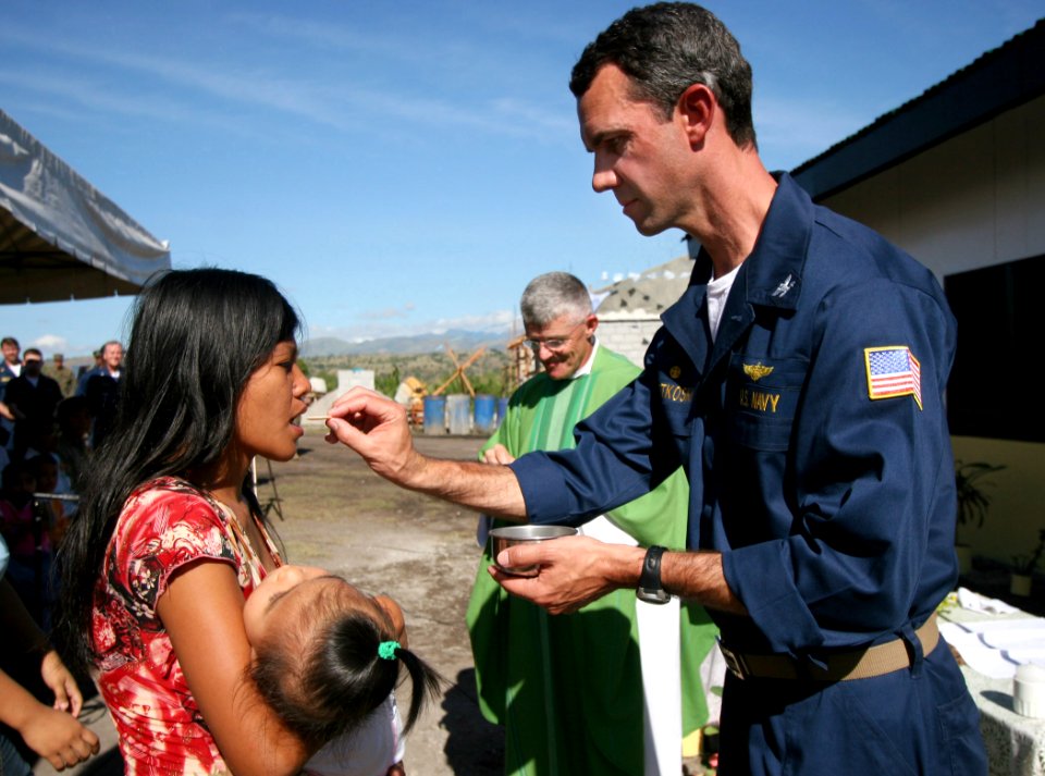 US Navy 070218-N-1113S-003 A Filipina receives communion from USS Blue Ridge (LCC 19) Commanding Officer Jeff Bartkoski during Sunday mass at Changco Elementary School