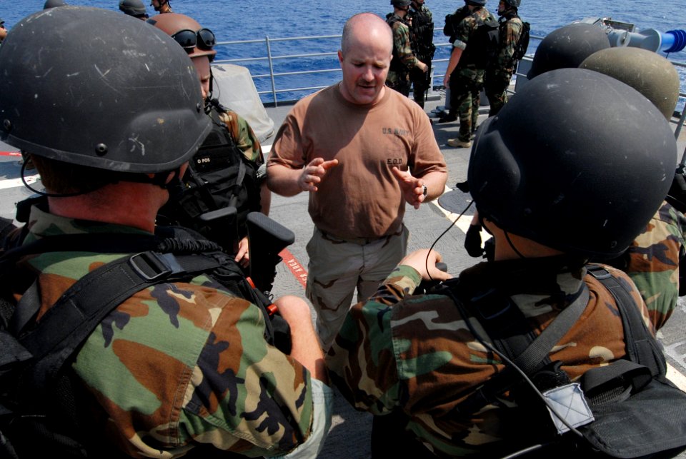 US Navy 070219-N-0684R-121 Explosive Ordnance Disposalman 1st Class Tim Idom instructs Sailors on proper boarding techniques during a Visit, Board, Search and Seizure (VBSS) drill