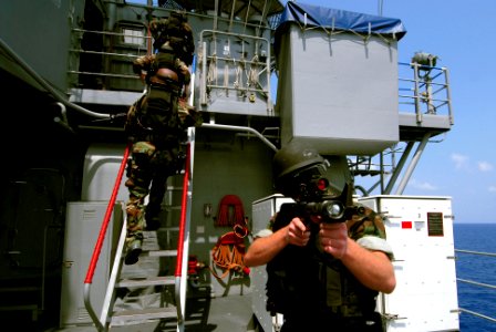 US Navy 070219-N-0684R-076 Gunners Mate 2nd Class Daniel Fisher covers the back portion of the ship as the rest of his team ascends a ladder during a visit, board, search and seizure (VBSS) drill aboard the Ticonderoga-class gu