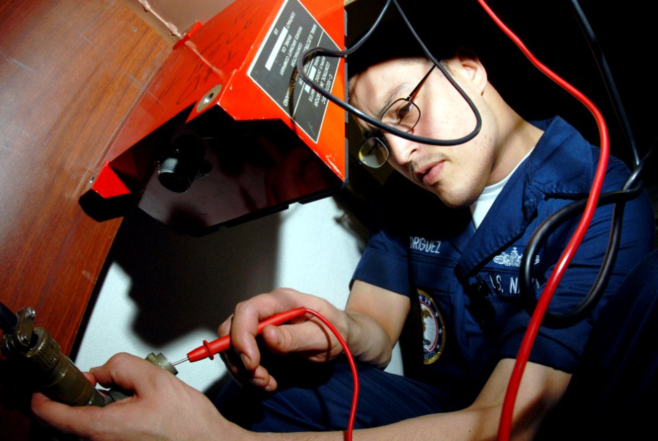 US Navy 070225-N-3038W-030 Electronics Technician Seaman Osman Rodriguez troubleshoots the ground wire on a malfunctioning telephone line aboard the Nimitz-class aircraft carrier USS John C. Stennis (CVN 74)