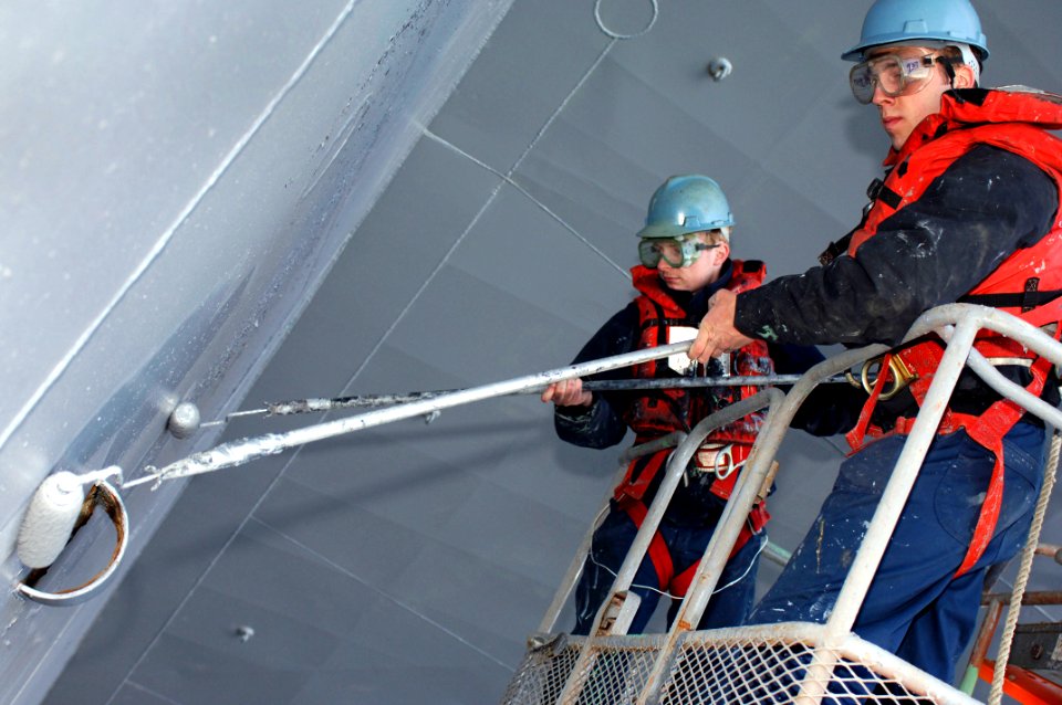 US Navy 070301-N-8591H-067 Boatswain's Mate Seaman Brent Webster, from Rapid City, N.D., and Air Traffic Controller Airman Kyle Colyer, from Hercules, Calif., paint USS Kitty Hawk's (CV 63) hull during the Selected Restricted A