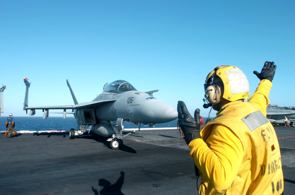 US Navy 070226-N-4420S-033 Aviation Boatswain's Mate 2nd Class William Moody directs an F-A-18E Super Hornet into position aboard nuclear-powered aircraft carrier USS Nimitz (CVN 68)