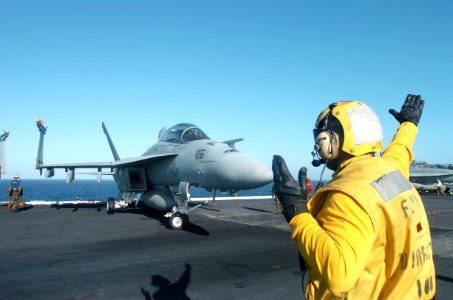 US Navy 070226-N-4420S-033 Aviation Boatswain's Mate 2nd Class William Moody directs an F-A-18E Super Hornet into position aboard nuclear-powered aircraft carrier USS Nimitz (CVN 68) photo