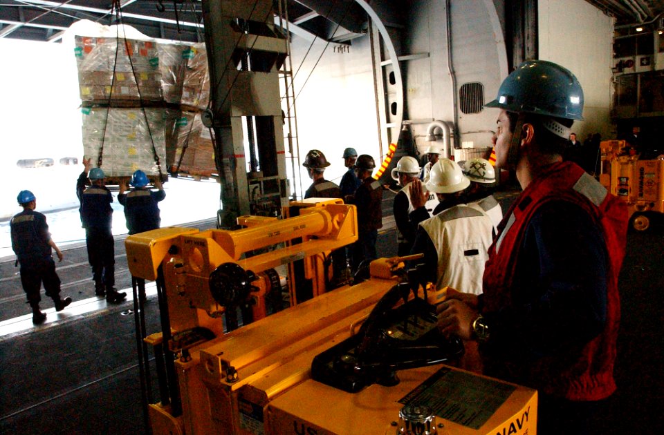 US Navy 070302-N-4009P-155 Aviation Ordnanceman Airman Issac Cardona from El Paso, Texas, stands by in a forklift ready to move a palette of cargo in hangar bay three of the Nimitz-class aircraft carrier USS Ronald Reagan (CVN