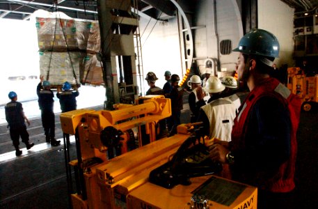 US Navy 070302-N-4009P-155 Aviation Ordnanceman Airman Issac Cardona from El Paso, Texas, stands by in a forklift ready to move a palette of cargo in hangar bay three of the Nimitz-class aircraft carrier USS Ronald Reagan (CVN