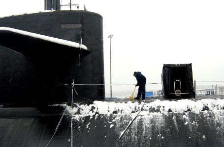 US Navy 070226-N-8467N-001 Machinist's Mate 2nd Class Alvin Anyiah removes snow from fast attack submarine USS Philadelphia (SSN 690) at Submarine Base New London photo