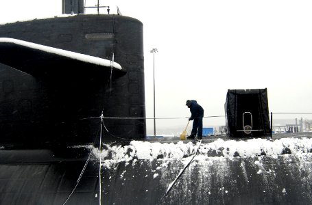 US Navy 070226-N-8467N-001 Machinist's Mate 2nd Class Alvin Anyiah removes snow from fast attack submarine USS Philadelphia (SSN 690) at Submarine Base New London