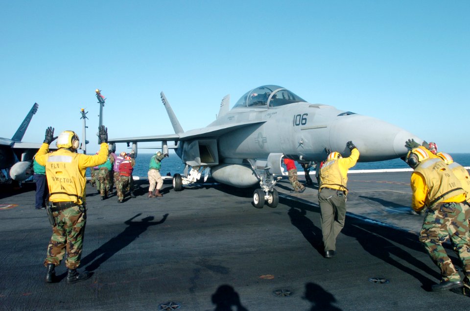 US Navy 070226-N-4420S-034 Flight deck personnel pitch in to push back an F-A-18E Super Hornet aboard nuclear powered-aircraft carrier USS Nimitz (CVN 68)