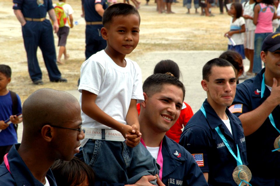 US Navy 070217-N-9604C-029 Musician 2nd Class Jesse D. Carmona carries a student on his shoulder at a 7th Fleet Band performance for Bawing Elementary School during a community service project