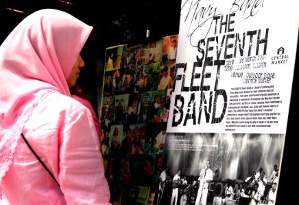 US Navy 070303-N-1113S-003 A local resident reads a poster advertising a 7th Fleet Band performance at the central market