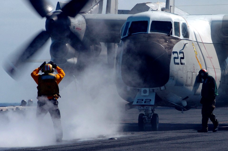US Navy 070225-N-4420S-078 Aviation Boatswain's Mate (Handling) 2nd Class William Moody directs an E-2 Hawkeye to a catapult aboard nuclear-powered aircraft carrier USS Nimitz (CVN 68)