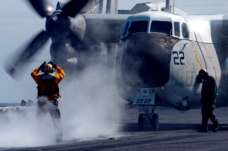 US Navy 070225-N-4420S-078 Aviation Boatswain's Mate (Handling) 2nd Class William Moody directs an E-2 Hawkeye to a catapult aboard nuclear-powered aircraft carrier USS Nimitz (CVN 68) photo