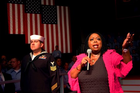 US Navy 070221-N-7883G-020 Singer and performer Carol Woods sings to service members in the hangar bay aboard USS Kitty Hawk (CV 63) prior to the visit by Vice President Dick Cheney