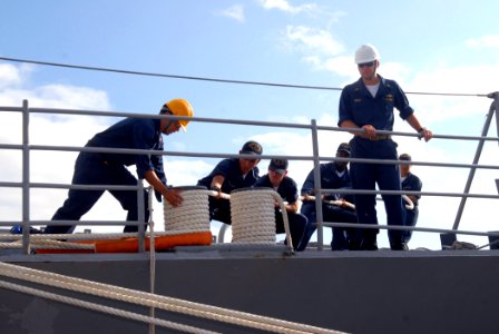US Navy 070304-N-4965F-005 Sailors assigned to guided missile cruiser USS Bunker Hill (CG 52) handle lines as she moors pierside Naval Station Pearl Harbor