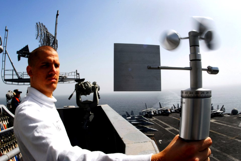 US Navy 070305-N-9928E-119 Aerographer's Mate 3rd Class Eric Wohlander uses a hand-held angomameter to measure relative winds in order to calculate true wind speed