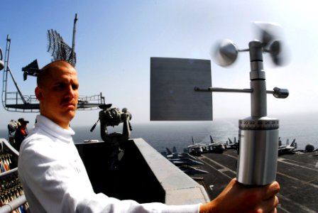 US Navy 070305-N-9928E-119 Aerographer's Mate 3rd Class Eric Wohlander uses a hand-held angomameter to measure relative winds in order to calculate true wind speed