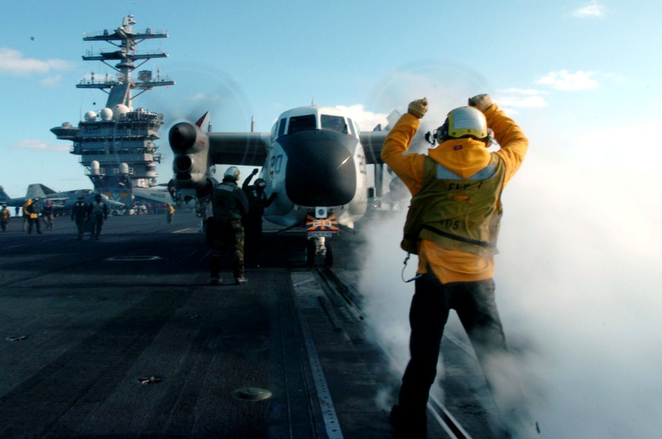 US Navy 070301-N-4420S-109 Aviation Boatswain's Mate (Handling) 3rd Class Baljeet Gill taxies an EA-6B Prowler assigned to the Black Ravens of Tactical Electronic Warfare Squadron (VAQ) 135 to the catapult aboard USS Nimi