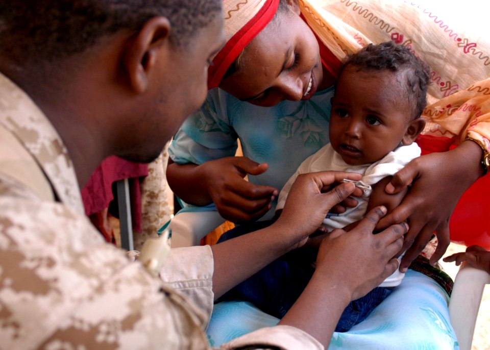 US Navy 070307-N-8154G-181 Hospital Corpsman 3rd Class Kenneth Russell takes the temperature of a small child during a Medical Civil Assistance Project (MEDCAP) at Barigoni School