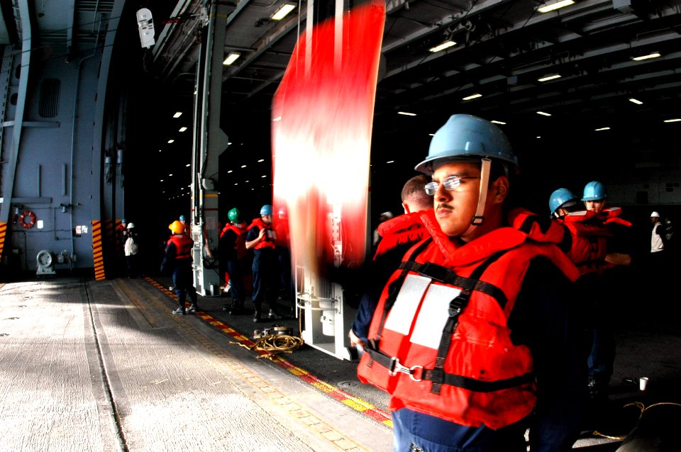 US Navy 070302-N-9760Z-036 Boatswain's Mate Seaman Nathan Mills signals to Military Sealift Command (MSC) fast combat support ship USNS Rainer (T-AOE 7) during an underway replenishment (UNREP)