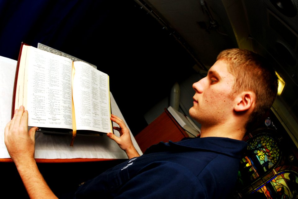 US Navy 070224-N-9928E-045 Airman Rick Mowry places a Bible in the chapel for Catholic Mass aboard Nimitz-class aircraft carrier USS John C. Stennis (CVN 74)