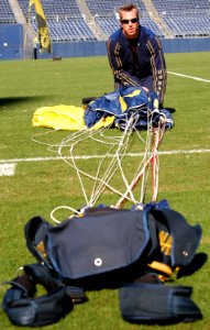 US Navy 070308-N-4163T-097 A member of the U.S. Navy Parachute Demonstration Team Leap Frogs repacks his parachute after landing into San Diego's Qualcomm Stadium during a training session