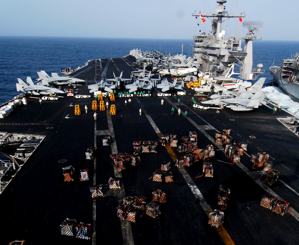 US Navy 070305-N-3729H-371 Sailors assigned to supply department aboard USS John C. Stennis (CVN 74) work diligently to transfer supplies from the flight deck to the hangar bay during a replenishment at sea