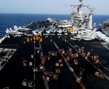 US Navy 070305-N-3729H-371 Sailors assigned to supply department aboard USS John C. Stennis (CVN 74) work diligently to transfer supplies from the flight deck to the hangar bay during a replenishment at sea