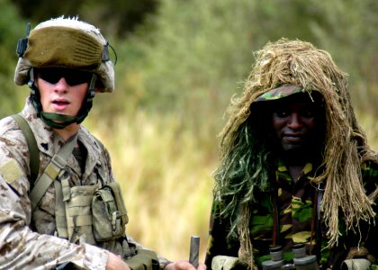 US Navy 070304-N-8154G-154 Marines with Battalion Landing Team (BLT) 2-2 Fox Company, 26th Marine Expeditionary Unit (MEU), and a member of the Kenyan Army stand by for a helicopter to land