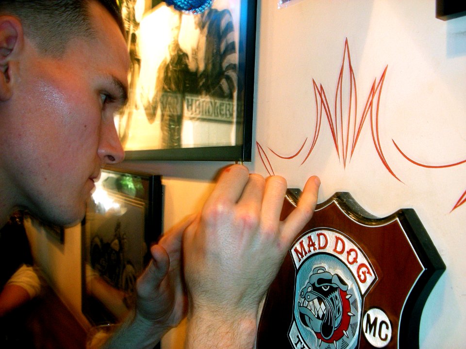 US Navy 070310-N-3659B-016 Mass Communication Specialist 3rd Class Jack McCann, a USS Ronald Reagan (CVN 76) Sailor from San Bernadino, Calif., paints a thin red line as part of his design for a pin-striping project at the Hand