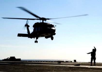 US Navy 070306-N-6524M-001 A landing signalman enlisted (LSE) directs an SH-60F Seahawk, attached to the Dragonslayers of Helicopter Antisubmarine Squadron (HS) 11, to the landing area on the flight deck of the nuclear-powered