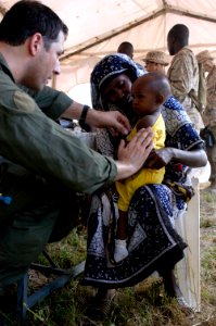 US Navy 070307-N-8154G-069 Hospital Corpsman 2nd Class Damon Baldini takes the temperature of a small child during a Medical Civil Assistance Project (MEDCAP) at Barigoni School