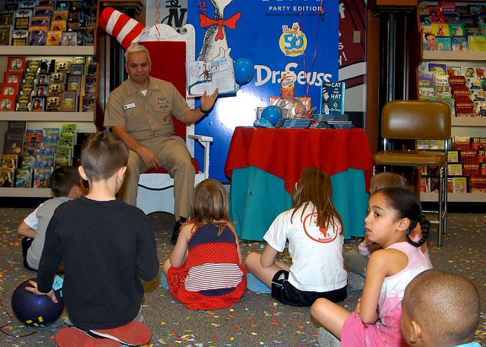 US Navy 070303-N-1082Z-004 Command Master Chief (CMDCM) Willie De Santiago, Naval Air Station Oceana, reads Cat in the Hat to children at the Oceana Navy Exchange (NEX) during the store's celebration of title character^rs