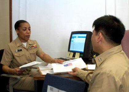 US Navy 070305-N-9520G-001 Chief Legalman Stacey Vine, a Volunteer Income Tax Assistant (VITA) with Commander Fleet Activities Yokosuka Tax Services assists Lt. Bienvenido Angeles of SRF-JRMC with his yearly taxes