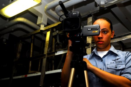 US Navy 070309-N-9928E-031 Mass Communication Specialist Seaman Leah Allen films a weapons exercise in weapons department's ordnance assembly division workshop photo