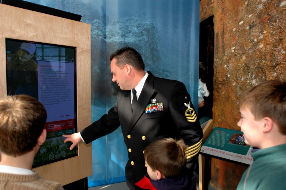 US Navy 070309-N-2456S-132 Senior Chief Hospital Corpsman Scott Allison, leading chief petty officer of Explosive Ordnance Disposal (EOD) Mobile Unit (MOBU) 2, explains an interactive video of the inner workings of the turret o