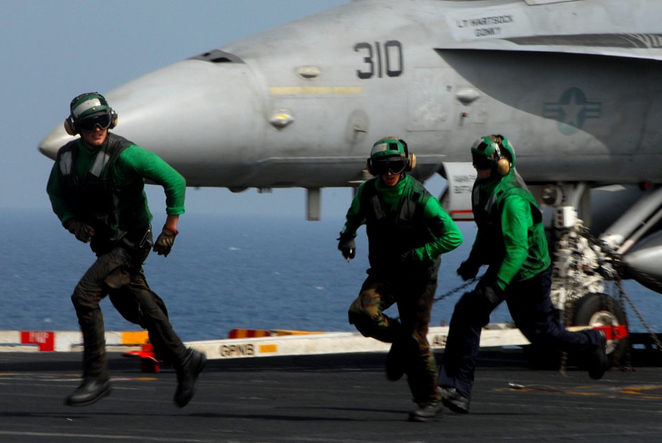 US Navy 070308-N-2659P-172 Sailors assigned to launch and recovery division aboard USS John C. Stennis (CVN 74) run across the landing area following inspection of the arresting gear wire after an aircraft boltered during recov