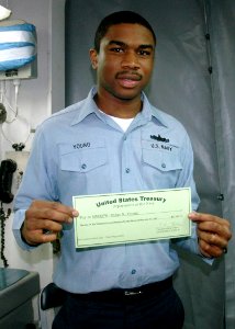 US Navy 070310-N-1328S-004 Machinist Mate 3rd Class Dylan Young assigned to amphibious assault ship USS Boxer (LHD 4) holds his selective reenlistment bonus (SRB) check