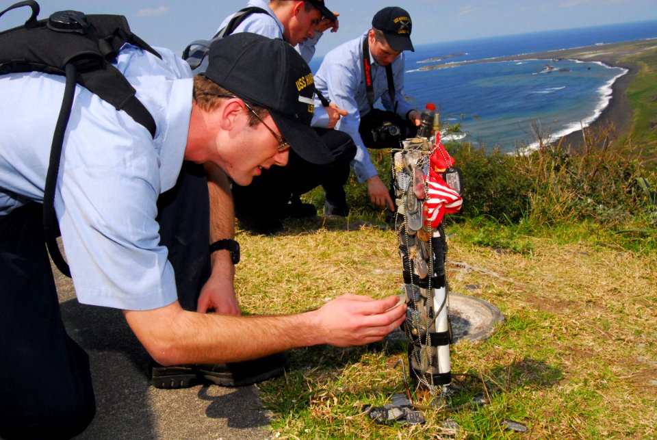 US Navy 070313-N-4124C-147 Postal Clerk Seaman Joshua Langland, assigned to USS Harpers Ferry (LSD 49), observes a dog-tag memorial dedicated to fallen service members of the Battle of Iwo Jima