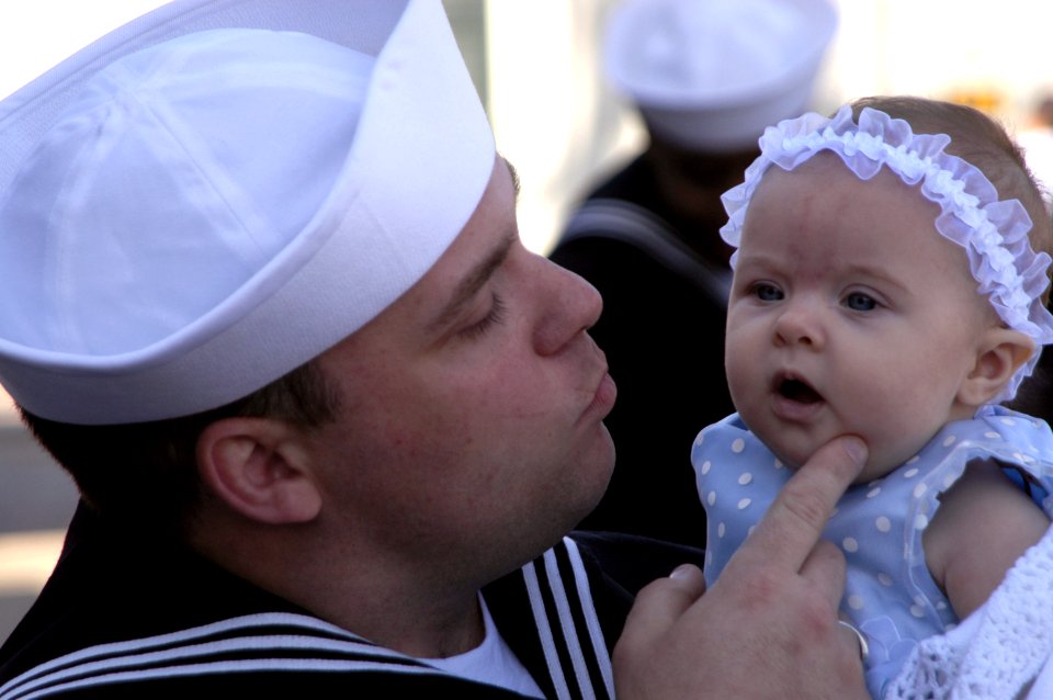 US Navy 070313-N-8158F-105 Electronics Technician 3rd Class Rick Pfeifer embraces his three-month old daughter for the first time at the homecoming ceremony for guided missile cruiser USS Bunker Hill (CG 73)