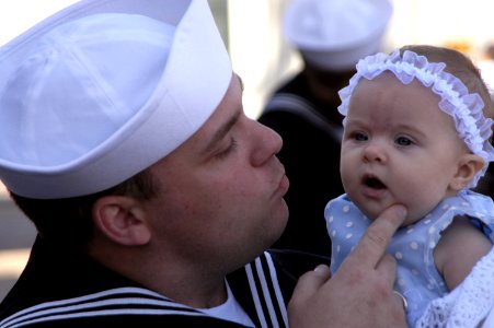 US Navy 070313-N-8158F-105 Electronics Technician 3rd Class Rick Pfeifer embraces his three-month old daughter for the first time at the homecoming ceremony for guided missile cruiser USS Bunker Hill (CG 73)