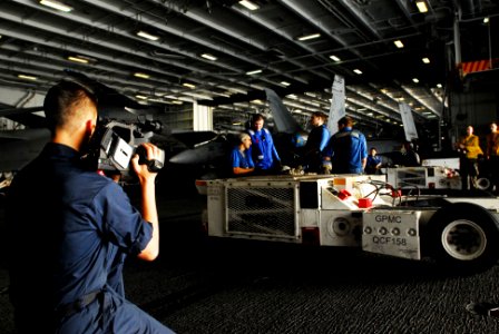 US Navy 070310-N-9928E-133 Mass Communication Specialist 3rd Class Elliot Fabrizio films sailors as they prepare to move an aircraft in the hangar bay aboard Nimitz-class aircraft carrier USS John C. Stennis (CVN 74)